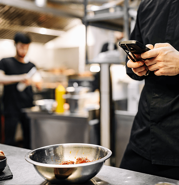 chef en cuisine qui prend une photo