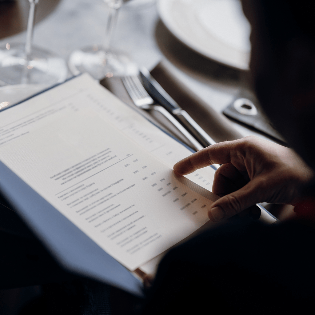 homme pointant un menu au restaurant