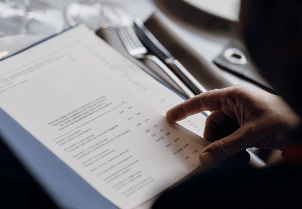 homme pointant un menu au restaurant